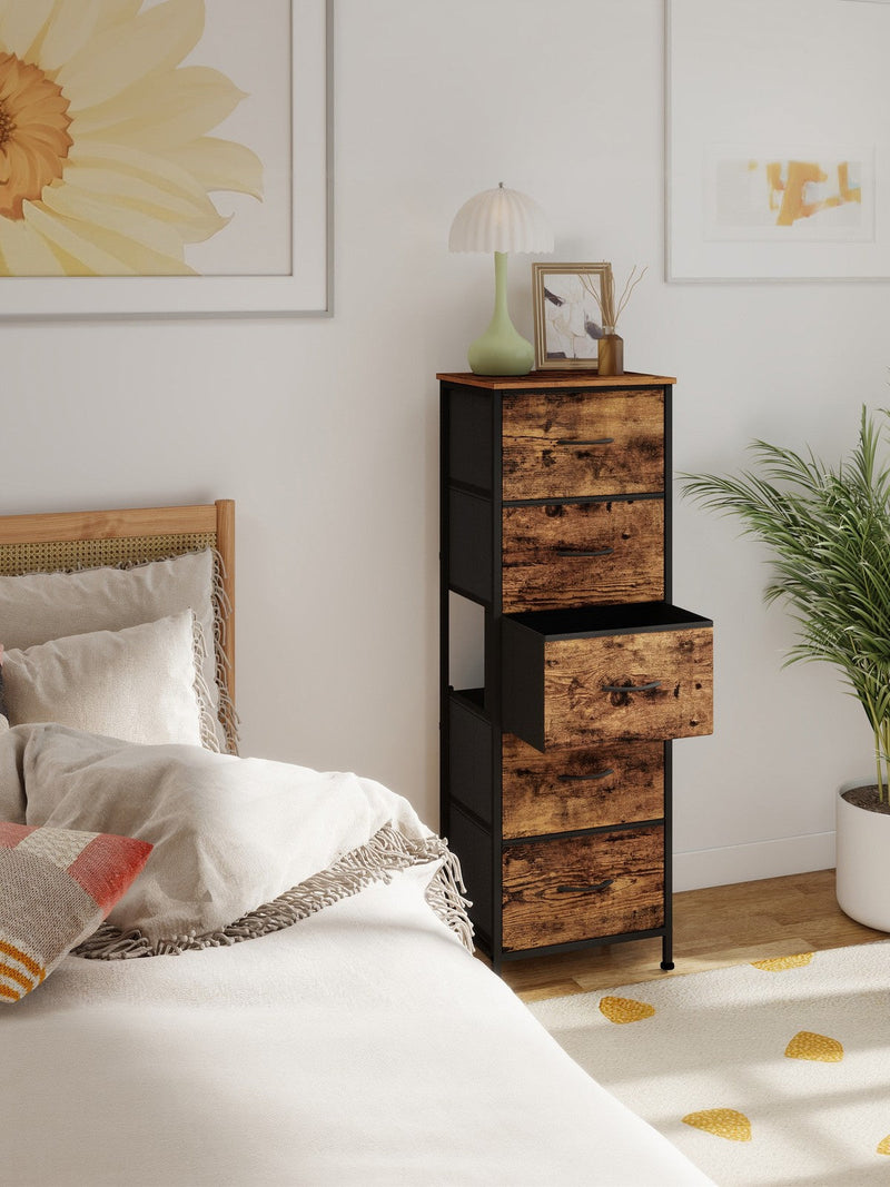 Chest of drawers beside a bed with the middle fabric drawer pulled open