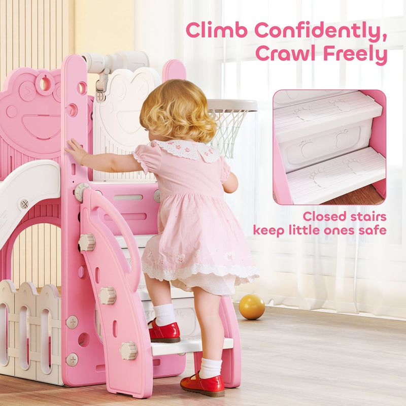 Toddler girl climbing the steps to reach the basketball hoop on the pink slide set