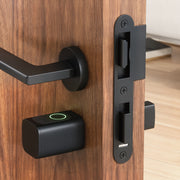 Smart door cylinder installed in a wooden door beside the handle