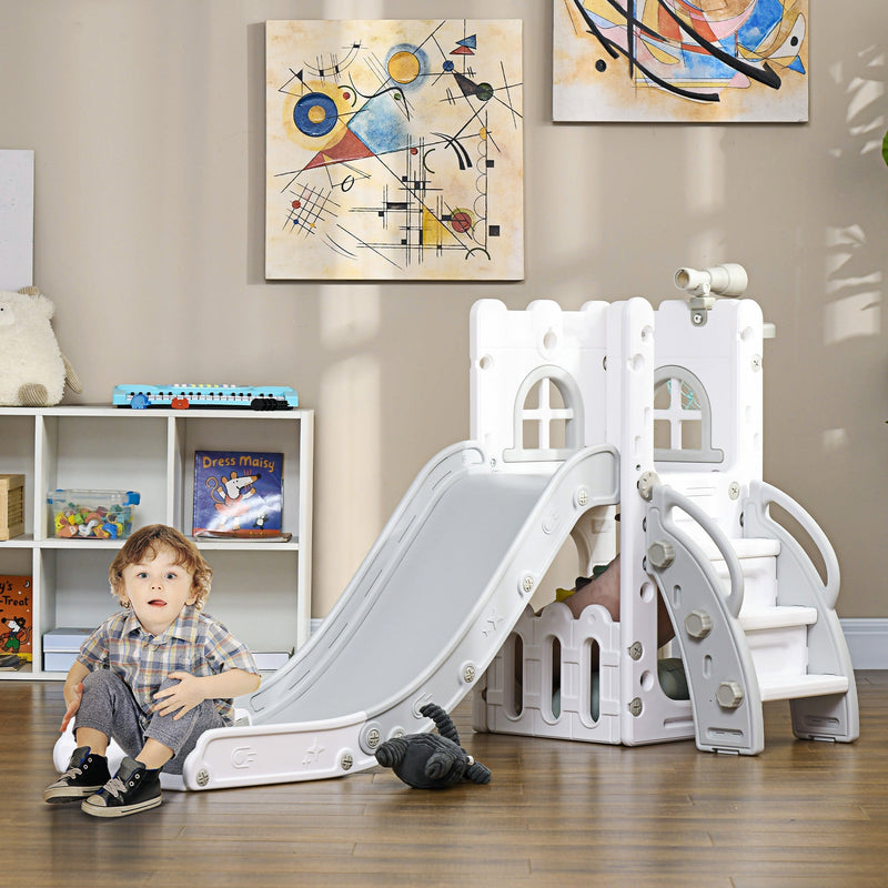 Toddler sitting beside the grey Aiyaplay slide in a playroom setting