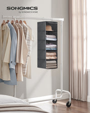 Grey hanging organiser on a white mobile clothes rail beside hanging shirts and jackets