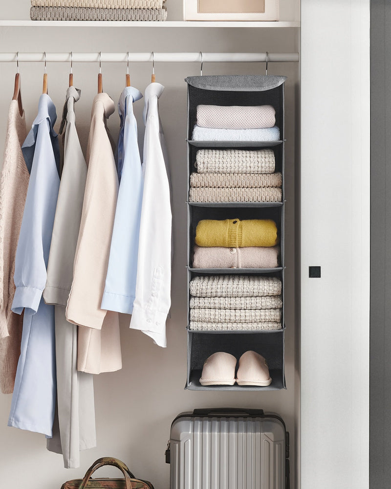 Grey hanging organiser at the end of a wardrobe rail holding folded jumpers, knitwear and slippers