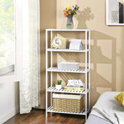White bamboo shelf styled in a living room corner with books and decor