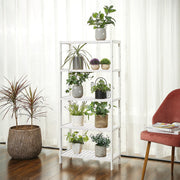 White bamboo shelf displaying potted plants against a curtained window