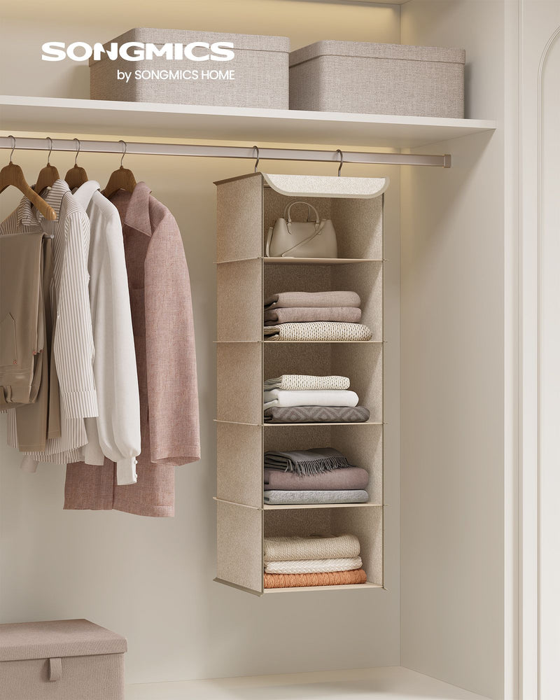 Sand beige hanging organiser in a wardrobe holding a bag, folded jumpers and towels