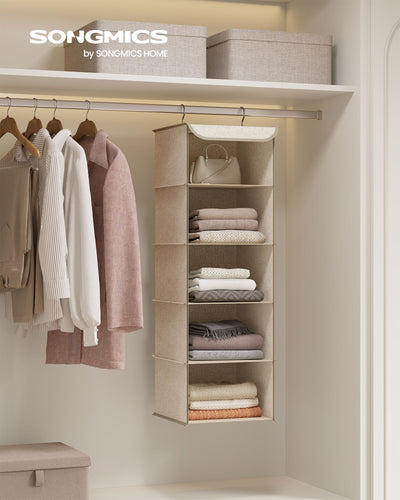 Sand beige hanging organiser in a wardrobe holding a bag, folded jumpers and towels