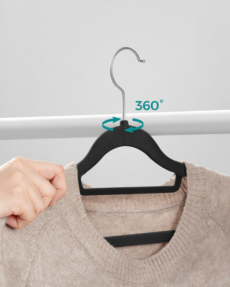 Hand demonstrating the 360 degree swivel hook on a black velvet hanger
