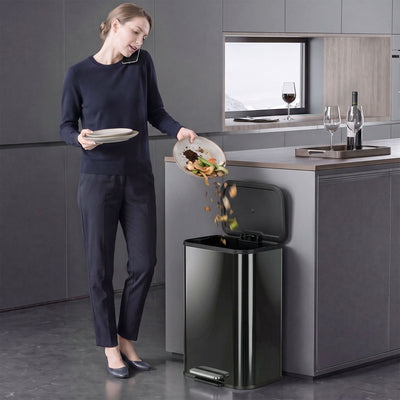 Woman scraping food waste into the Homcom pedal bin with the lid open