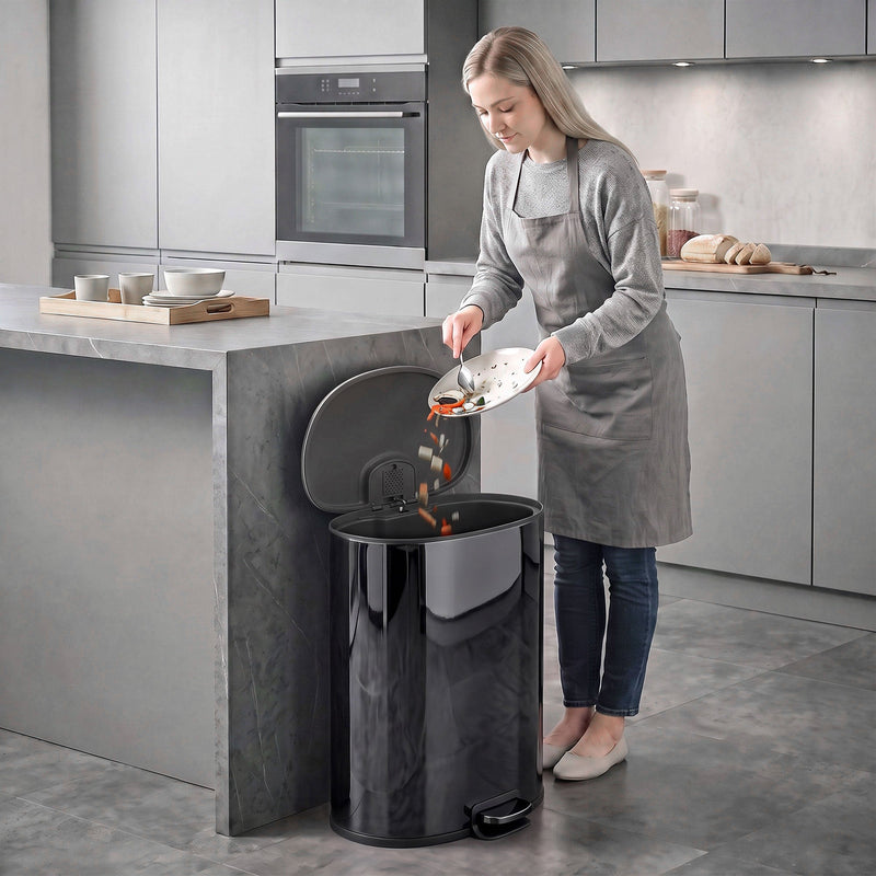 Woman scraping food into the open black pedal bin in a modern kitchen