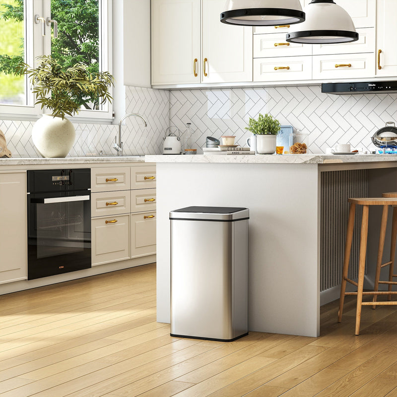 Silver sensor bin in a white and gold-accented kitchen beside an oven and bar stools