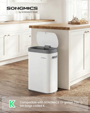 White Songmics motion sensor kitchen bin styled beside a kitchen island