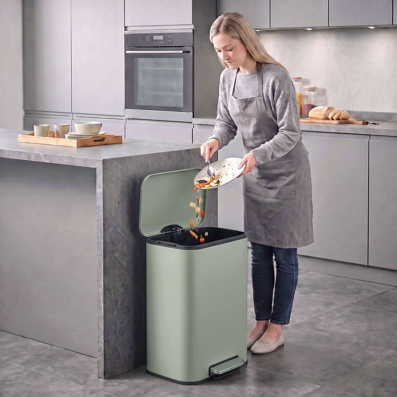 Woman scraping food into an open light green 50L pedal bin in a modern kitchen