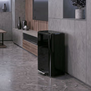 Black 50L pedal bin standing beside a TV unit in a living room