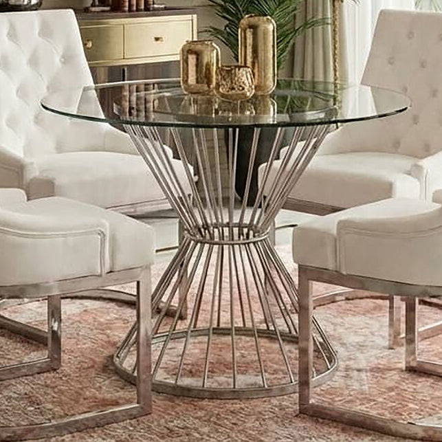 Clear glass round dining table with silver hourglass base in a dining room setting