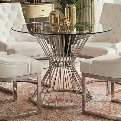 Clear glass round dining table with silver hourglass base in a dining room setting