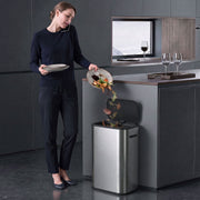 Woman scraping food scraps into the open HOMCOM sensor bin in a modern kitchen