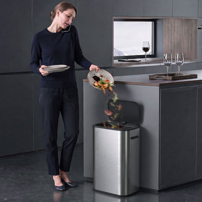 Woman scraping food scraps into the open HOMCOM sensor bin in a modern kitchen