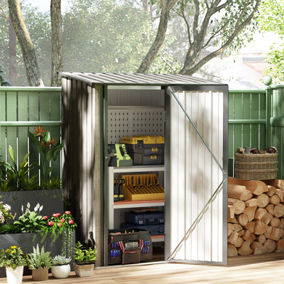 Shed open in a garden beside a green fence with tools, shelving and logs stored inside