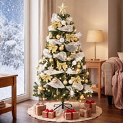 Decorated tree in a living room by a snowy window with gifts on a cream tree skirt