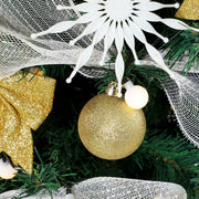 Close-up of a gold glitter bauble, white snowflake ornament, mesh ribbon and gold bow
