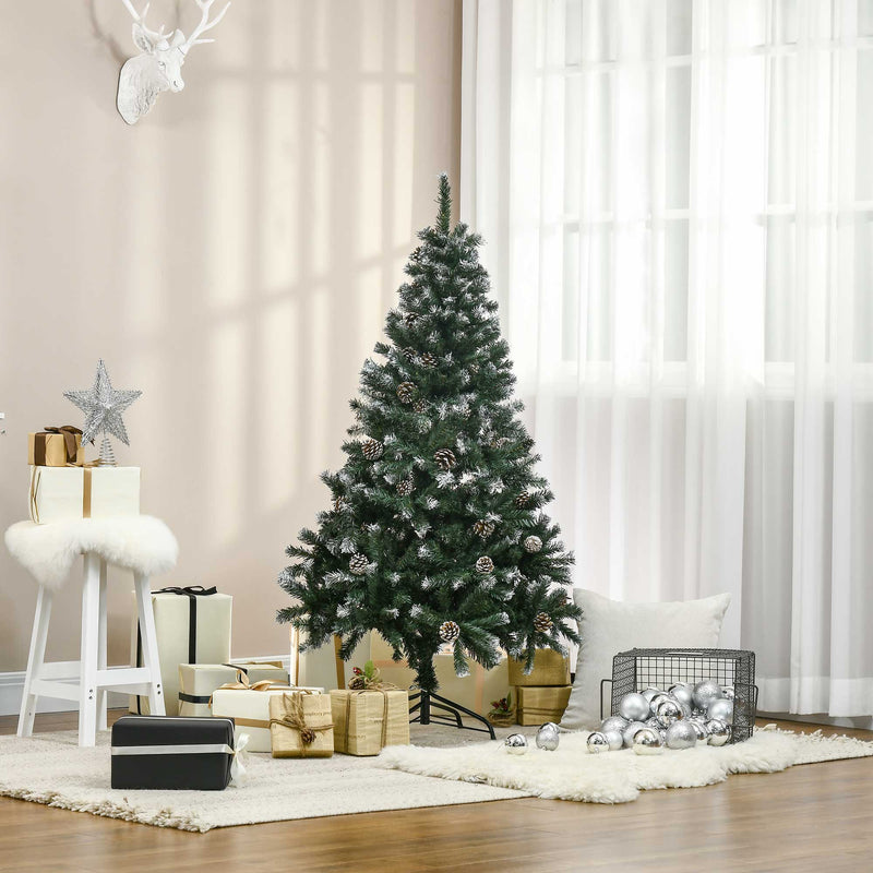 Snow flocked green Christmas tree in a living room beside a stool and wrapped gifts