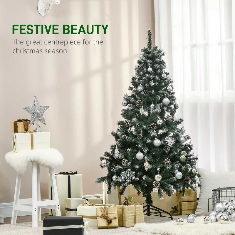 Snow flocked Christmas tree dressed with silver baubles beside gifts and a white stool