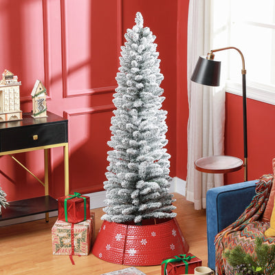 Snow-flocked pencil Christmas tree in a red living room with a red tree skirt and wrapped gifts