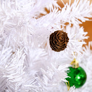Close-up of a pine cone and a green bauble on white branches