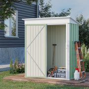 The green lean-to shed against a dark house wall with the door open, holding a spade, step ladder and tool boxes