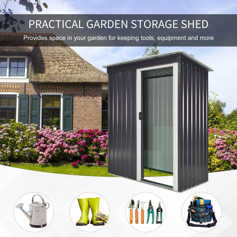 Black metal storage shed on a lawn in front of a thatched cottage with watering can and boots
