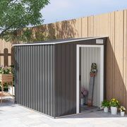 Dark grey 5x7ft metal shed sited along a fence with its sliding door open and tools inside