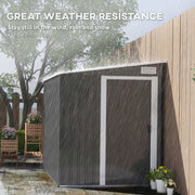 Dark grey metal shed standing in heavy rain beside a fence, showing its weather resistance