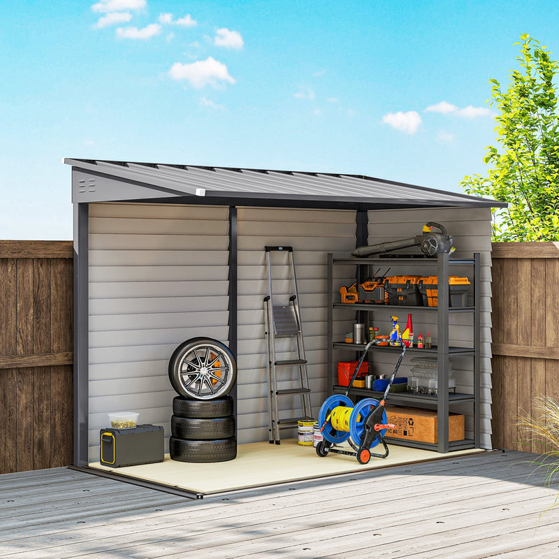 Cutaway view of the grey shed against a fence holding tyres, shelving, a hose reel and a step ladder