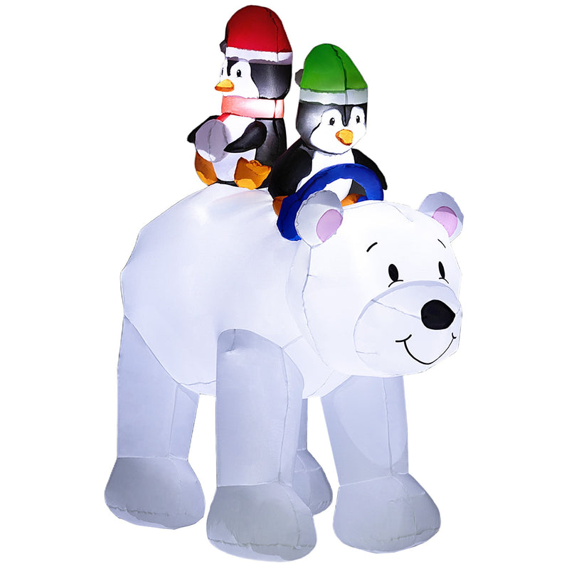 Inflated white polar bear carrying two penguins in red and green hats on a plain background