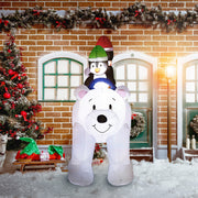 Polar bear and penguin inflatable on a snowy street in front of a brick shopfront with garlands