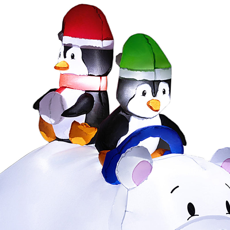 Close-up of the two penguins in red and green hats riding on the bear's back