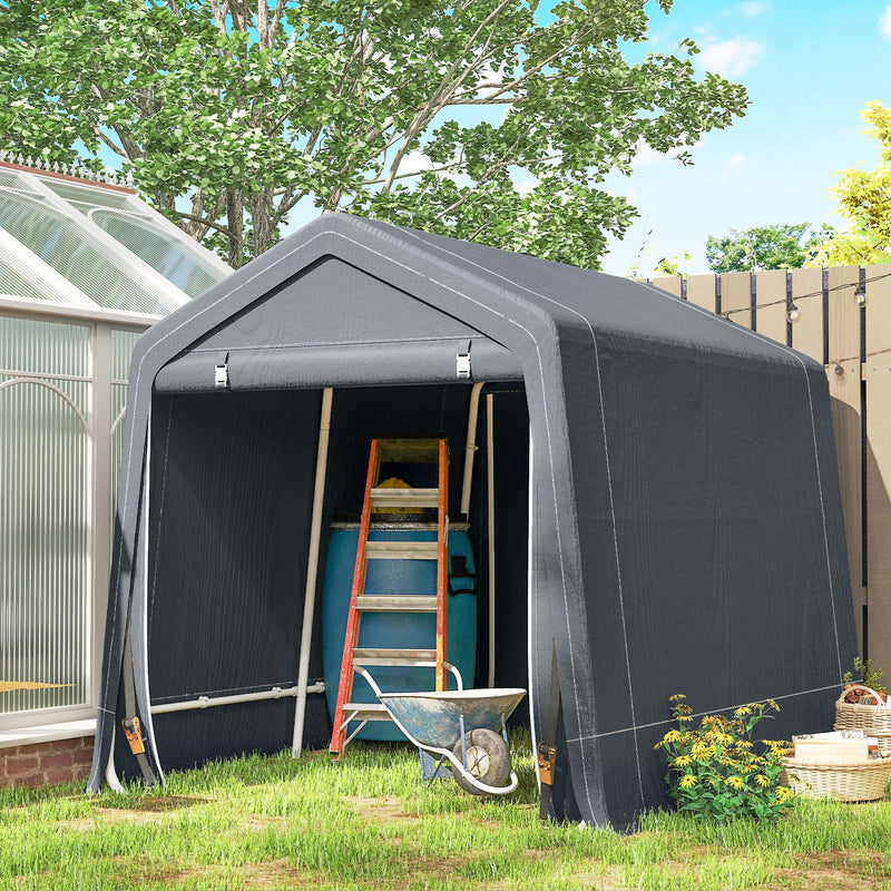 Dark grey shed storing a ladder, water butt and wheelbarrow next to a greenhouse