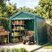 Green shed on a patio storing plant pots, shelves, a wheelbarrow and firewood