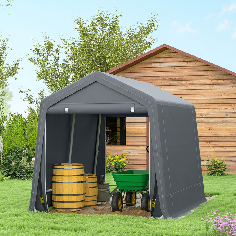 Dark grey shed beside a timber outbuilding storing barrels and a wheelbarrow