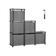 Black-framed 6-cube storage unit built in a step shape with six grey fabric boxes and a rubber mallet