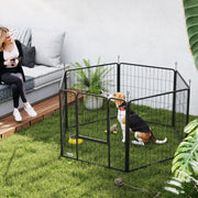 Black dog playpen set up on a garden lawn with a dog inside
