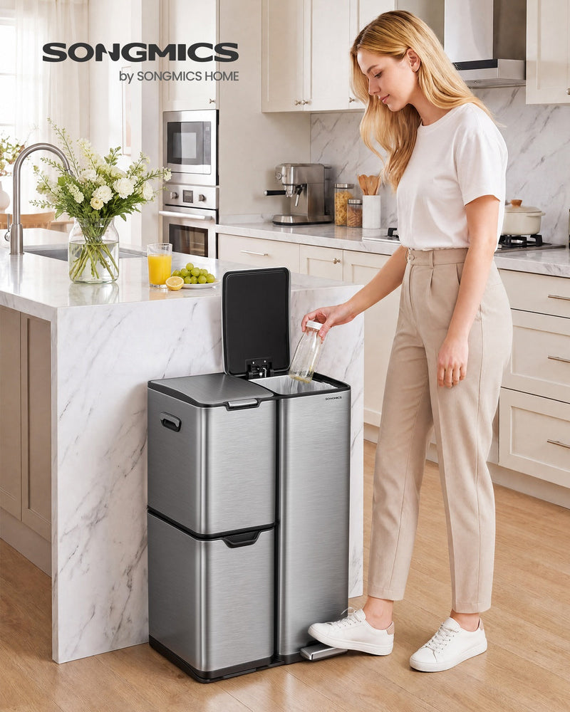 Woman dropping a bottle into the open compartment of the silver recycling bin in a kitchen