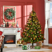 Lit Christmas tree with red baubles beside a white fireplace in a red-walled room