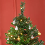 Close-up of silver and gold baubles and warm white lights on the branches