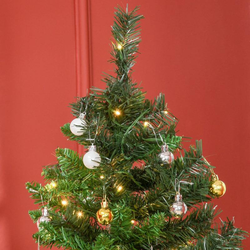 Close-up of silver and gold baubles and warm white lights on the branches