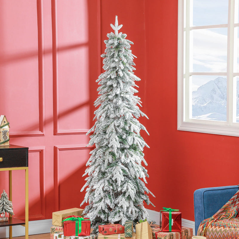 Slim snowy tree against a red wall beside a blue sofa and wrapped gifts