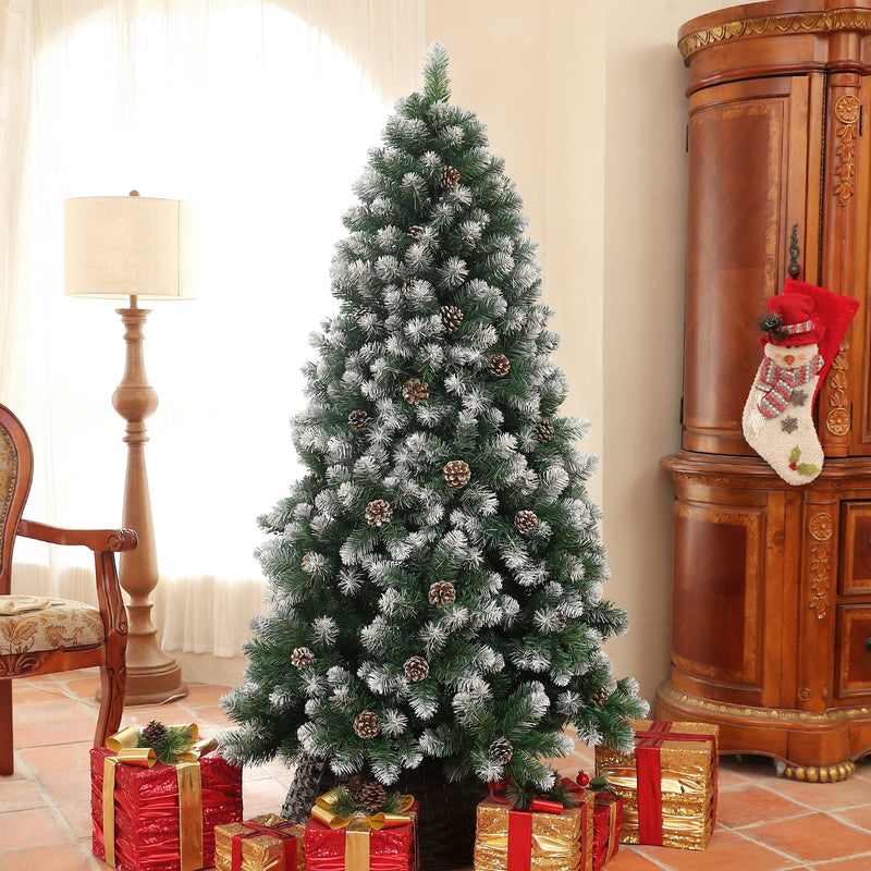 Snow-dipped pine tree in a lounge beside a lamp and Christmas stocking