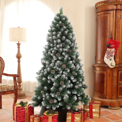 Snow-dipped pine tree in a lounge beside a lamp and Christmas stocking