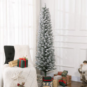Tall snowy pencil Christmas tree in a bright room beside an armchair and wrapped gifts