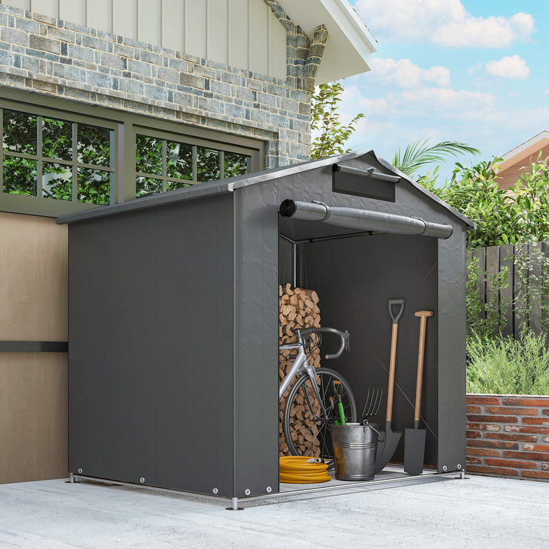 Side view of the shed on a paved area with firewood, a bike and tools inside